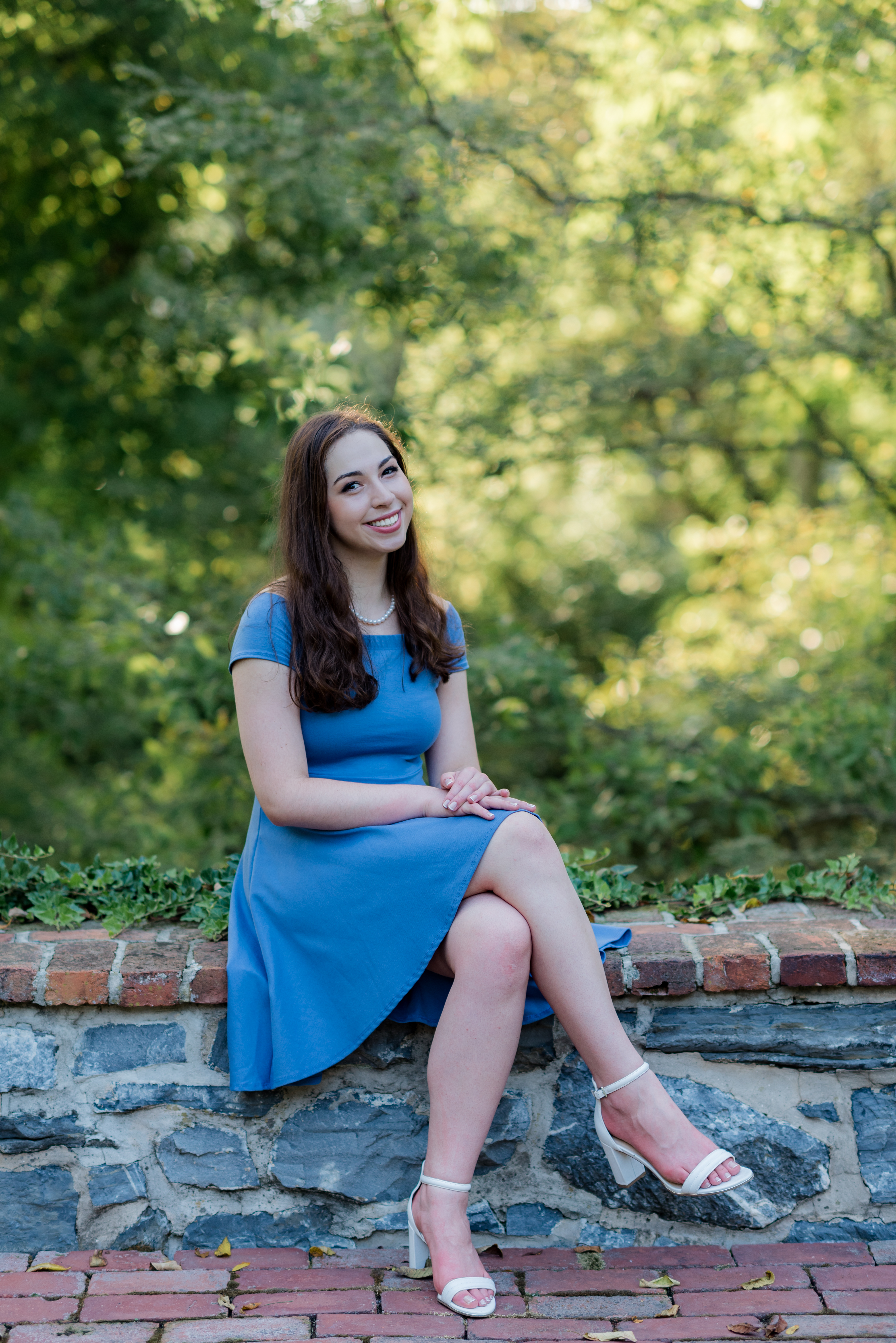Full body portrait of Olivia Gallucci sitting on rock wall. Used on my double-major post. (Should convert to webp).